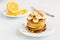 Stack of homemade pancakes with banana, maple syrup and walnuts on vintage plate.