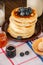 Stack of homemade pancakes in a plate, milk in a jar, jam preserves. Rustic style,