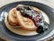 Stack of homemade shrovetide carnival pancakes on blue plate on rustic country table. Soft focus. Copy space. Pancake carnival