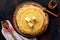 Stack of homemade thin pancakes with pieces of butter, milk and honey on old rustic ceramic plate.