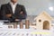 Stack of increasing coins and house model with businessman cross