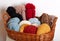 Stack of knitted hats and yarns in a basket