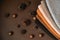 Stack of knitted material from threads of brown, orange, gray colors with pine cones a brown background. Top view. Copy, empty