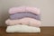 Stack of knitted sweaters on wooden table