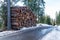 Stack of logs along a deserted mountain road on a clear winter day