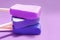 Stack of lollipops in shades of purple on lilac background.with copy space