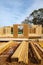 Stack of lumbers in front of timber frame house with post, beam, OSB (Oriented Strand Board) plywood sheathing