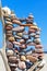 Stack of multicolored balanced stones on an old wooden snags, on a blue sky and sea background