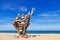 Stack of multicolored balanced stones on an old wooden snags, on a blue sky and sea background