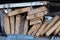 Stack of natural uneven rough wooden boards of different sizes, sectional view. Lumber for construction