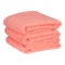 A stack of neatly folded clean fluffy orange towels isolated