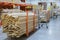 stack new wooden bars on shelves inside lumber yard of large hardware store in America. Rack of fresh mill or cut wood timber with