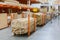 stack new wooden bars on shelves inside lumber yard of large hardware store in America. Rack of fresh mill or cut wood timber with