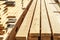 Stack of new wooden studs at the lumber yard. Timber on the construction site to dry. Background of sawed and processed wood of