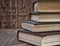 Stack of old books on a brown wooden background
