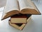 A stack of old books on a light surface. Books are shifted relative to each other.