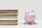 Stack of old books with piggy bank. Cost of education. Saving money for college. Save and pay for child college