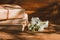 A stack of old books on a wooden background with a sprig of a flowering tree. the concept of memorabilia