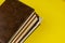 Stack of old diaries lying on yellow background