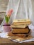 Stack of old hardback books and hyacinth on wooden background. Copy space
