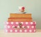 Stack of old suitcase, books and vintage tea cup over wooden table. retro style image