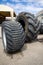 Stack of old used tires of different sizes and types in abandoned scrap yard.