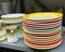 Stack of old used vintage colorful dinner plates dishes in thrift shop