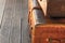 Stack of old and weathered brown suitcases, a couple of luggage lie on the wooden floor of the railway station copy space