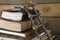 A stack of old wooden books, with miniature wooden ladder and tiny wooden book