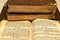 Stack of old and worn leather cover books with gold leaf embossing