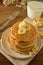 Stack of pancakes with banana slices and honey, on wooden background. Homemade american pancakes, isolated