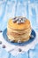 Stack of pancakes on a blue plate with frozen blueberry