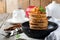 Stack of pancakes from buckwheat flour with baked apples and cinnamon on old wooden background. A healthy breakfast.