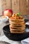 Stack of pancakes from buckwheat flour with baked apples and cinnamon on old wooden background. A healthy breakfast.