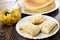 Stack of pancakes in dish, pancakes with apple filling in plate, apples with sugar syrup, spoon in bowl on table