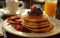 A stack of pancakes generously topped with fresh berries and drizzled with syrup, creating a delicious and indulgent