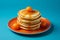 a stack of pancakes on an orange plate