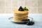 Stack of pancakes with pile of blueberries on plate