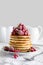 Stack of pancakes with raspberry, red currant, cream and honey