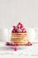 Stack of pancakes with raspberry, red currant, cream and honey