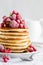 Stack of pancakes with raspberry, red currant, cream and honey