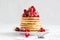 Stack of pancakes with raspberry, red currant, cream and honey