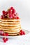 Stack of pancakes with raspberry, red currant, cream and honey