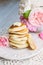 Stack of pancakes on white plate with lovely pink roses, shabby style