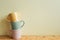 Stack of pastel color mug cups on wooden table. ivory wall background. kitchen and cafe concept