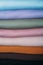 Stack of Pastel natural color Fabrics on white background. Fabrics And Clothing Arranged In Neat Stacks. Fabrics pile