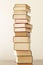 Stack of piled books rest on a wooden table with copy space for your text