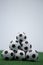 Stack of piled up football soccer balls on artificial grass