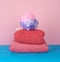 Stack of pink folded towels and a plastic washcloth on a blue background