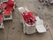 Stack of plastic chaise lounge with closed sunshades on wet sea side cement beach top view